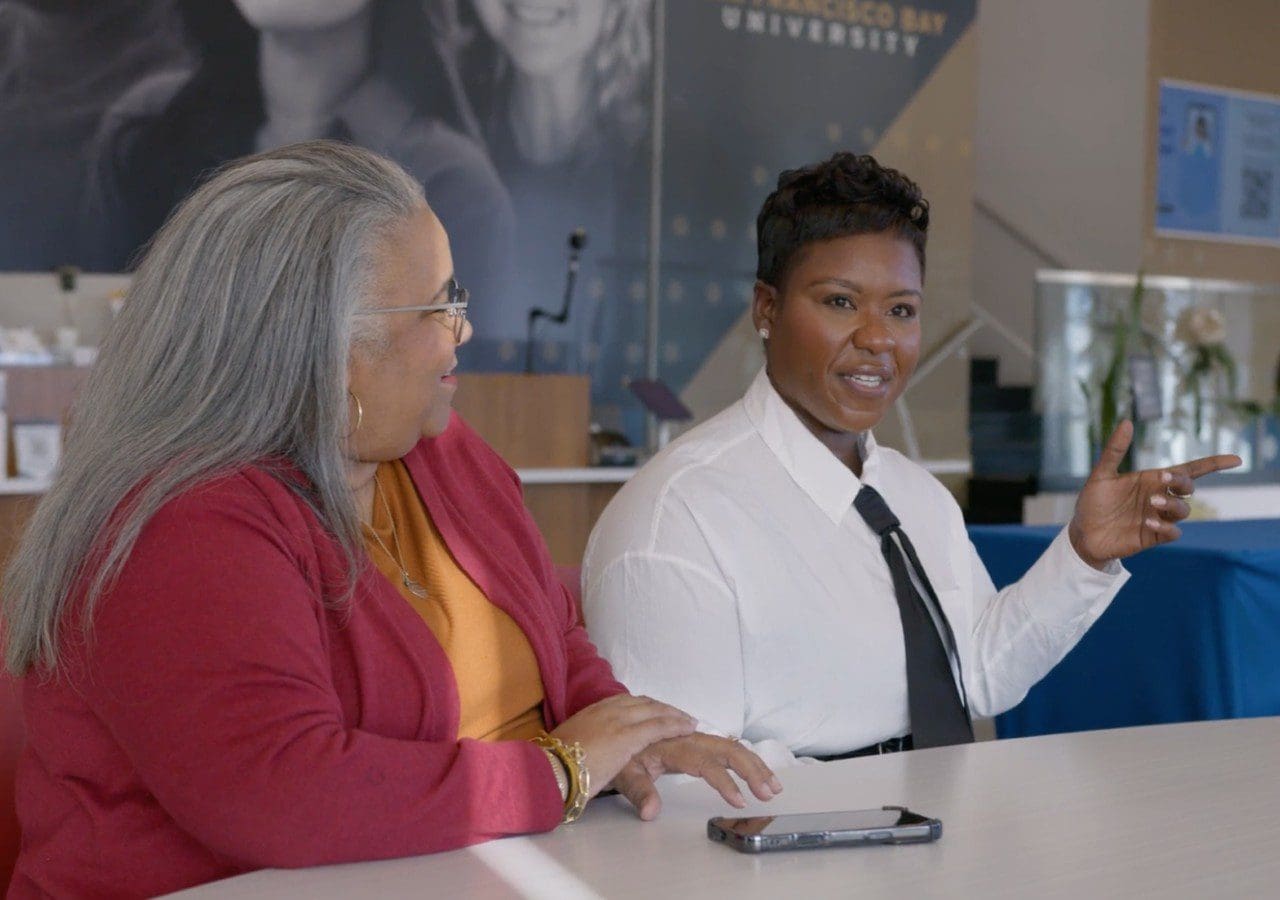 Two women engaged in a discussion at a meeting table.