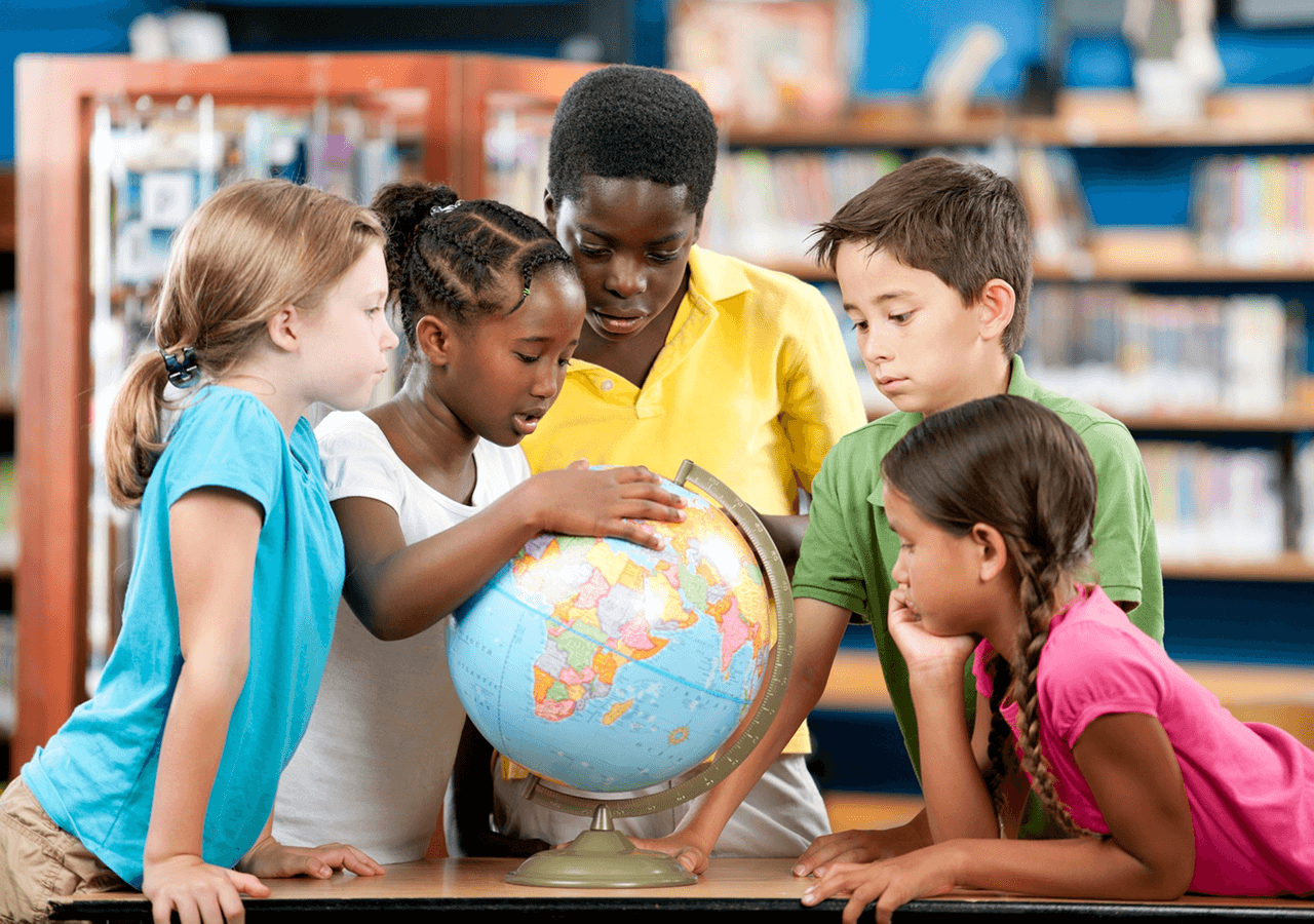 Children exploring a globe together in a classroom.