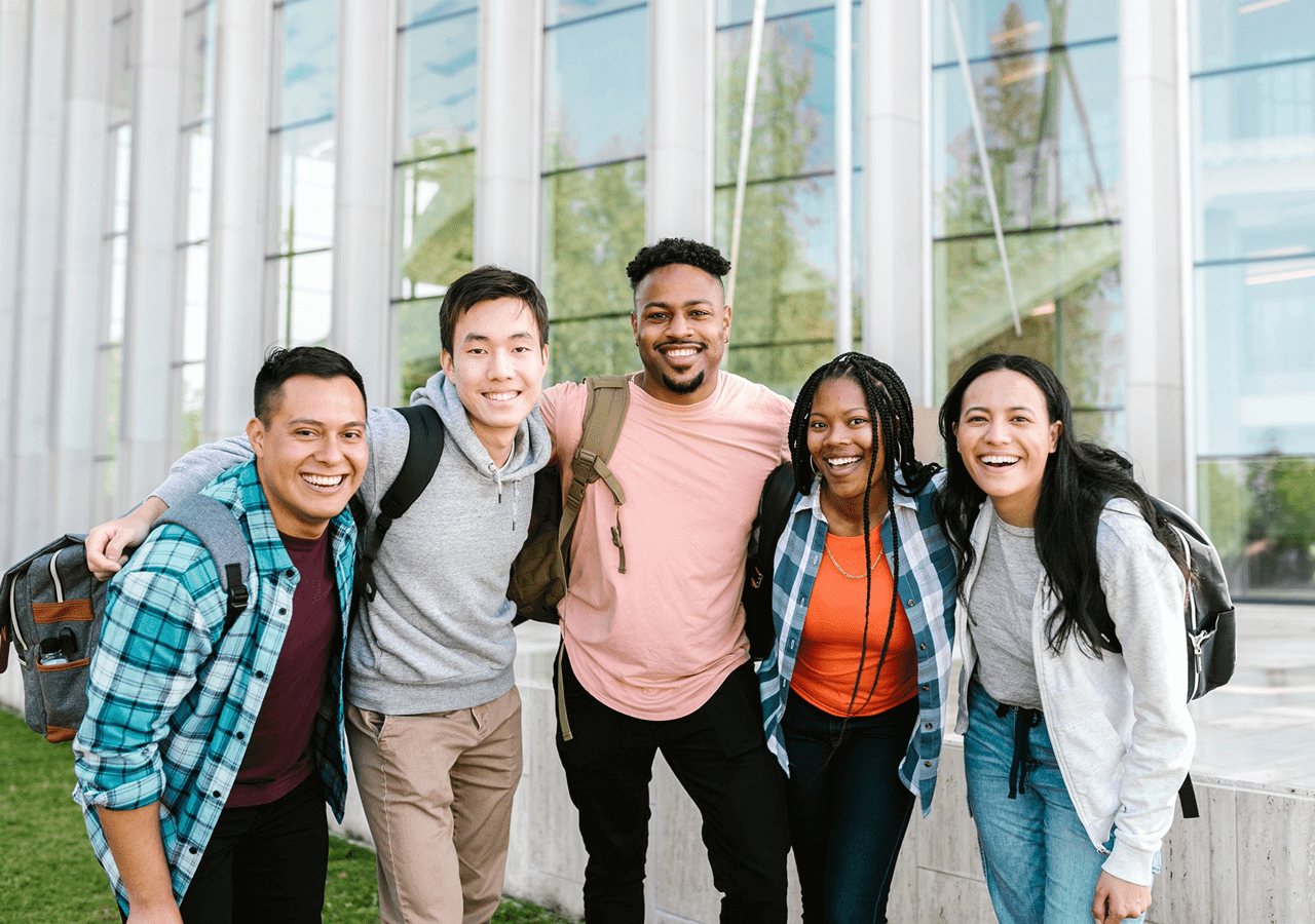 Diverse group of friends smiling outdoors in casual wear.