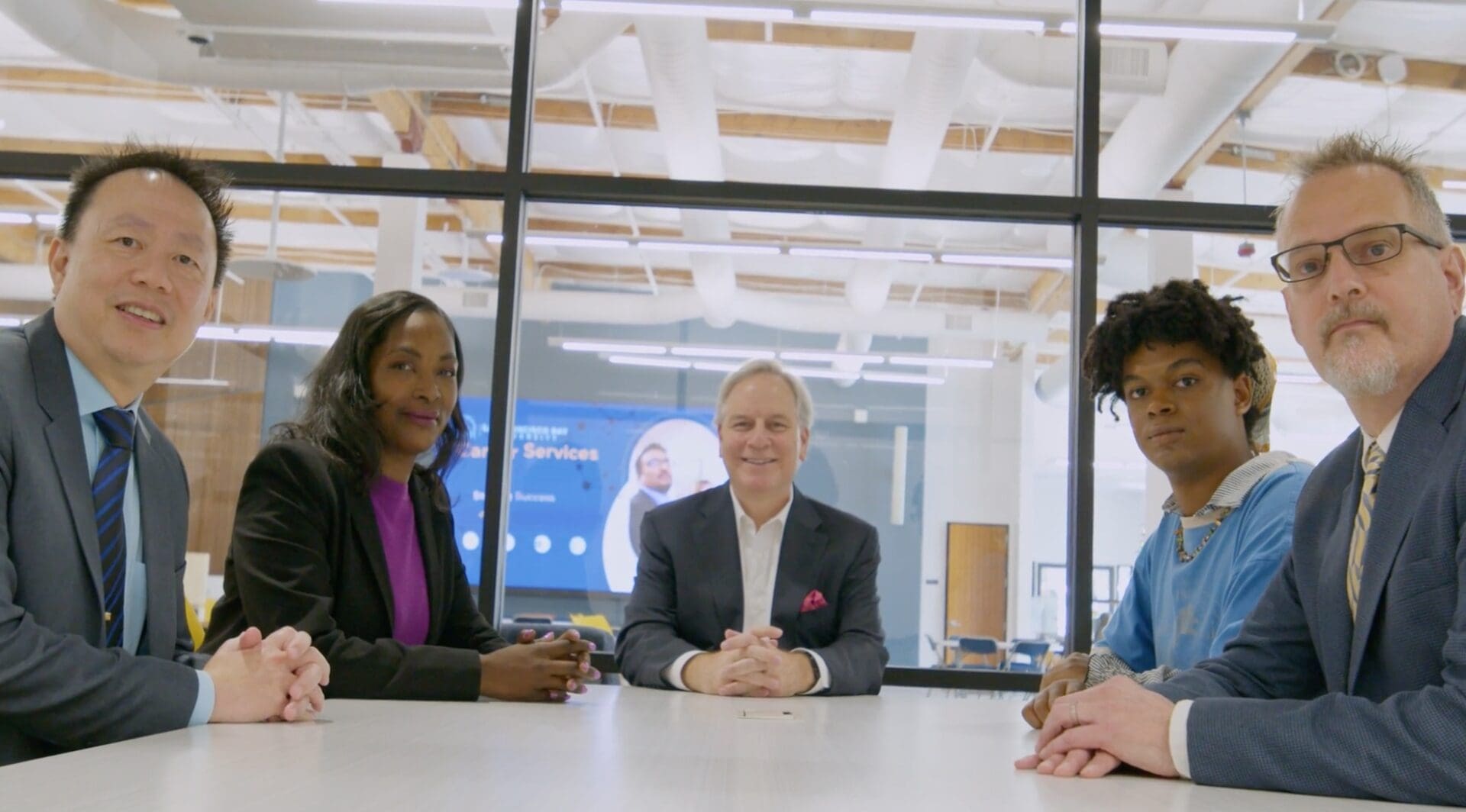 Three professionals sitting at a conference table during a meeting.