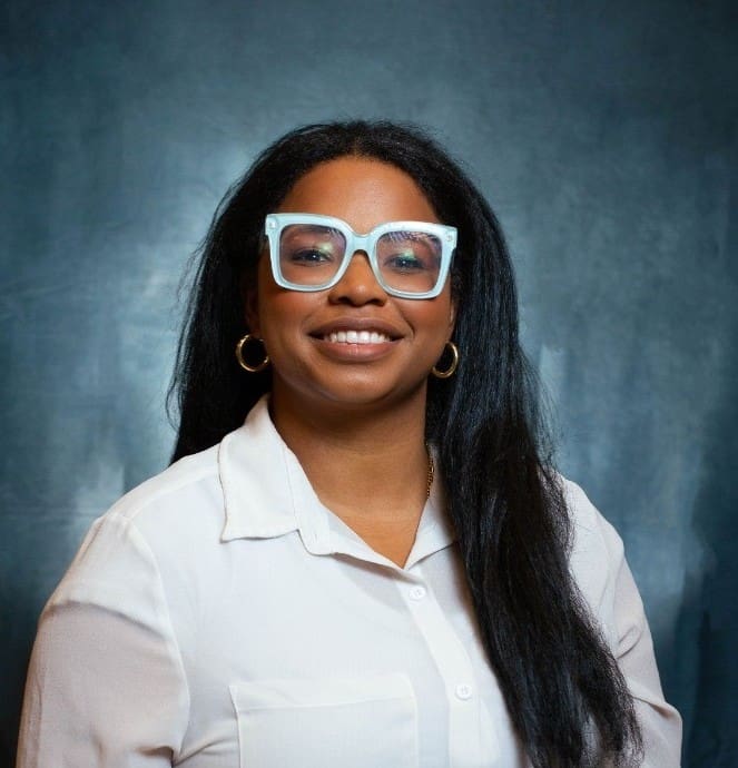 Smiling woman with blue glasses and white shirt